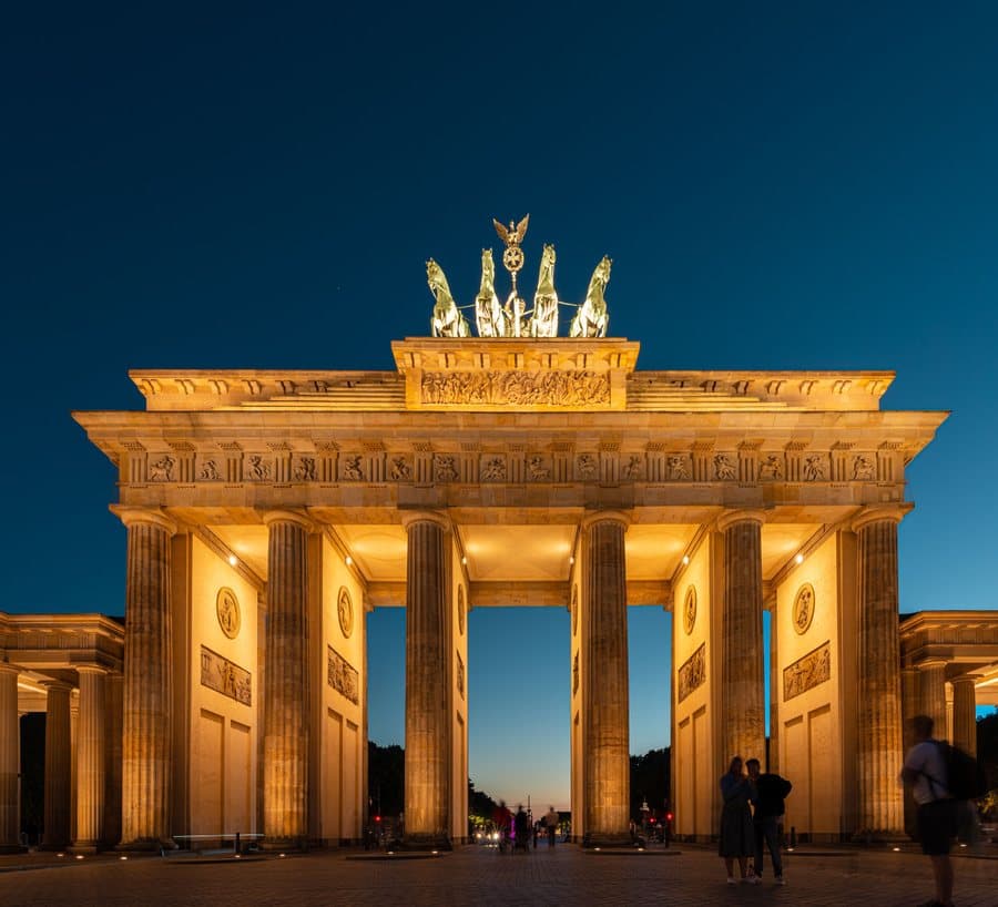 The Brandenburg Gate in Berlin lit up at dusk, a landmark anchoring a city destination quest.
